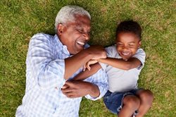 Grandfather and grandson playing outdoors on grass