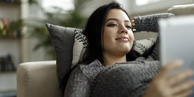 Teenager looking at ipad on couch