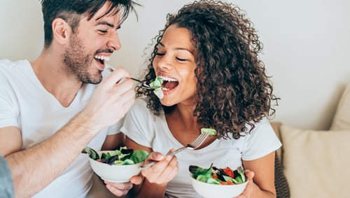 happy couple eating a salad together